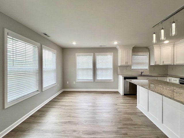 402 Pine St, Pulaski, TN 38478 - kitchen featuring stainless steel dishwasher, a sink, white cabinetry, baseboards, and light stone counters