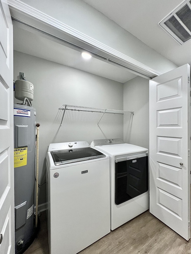 402 Pine St, Pulaski, TN 38478 - washroom featuring water heater, washer and dryer, and light wood-type flooring
