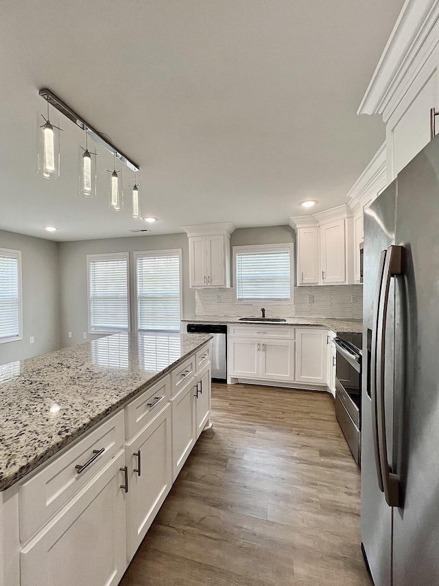402 Pine St, Pulaski, TN 38478 - kitchen with appliances with stainless steel finishes, a sink, white cabinets, backsplash, and light stone countertops