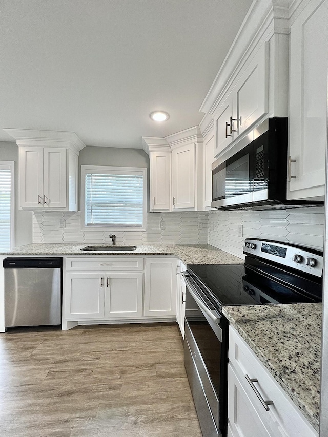 402 Pine St, Pulaski, TN 38478 - kitchen featuring stainless steel appliances, a sink, white cabinetry, light stone countertops, and backsplash