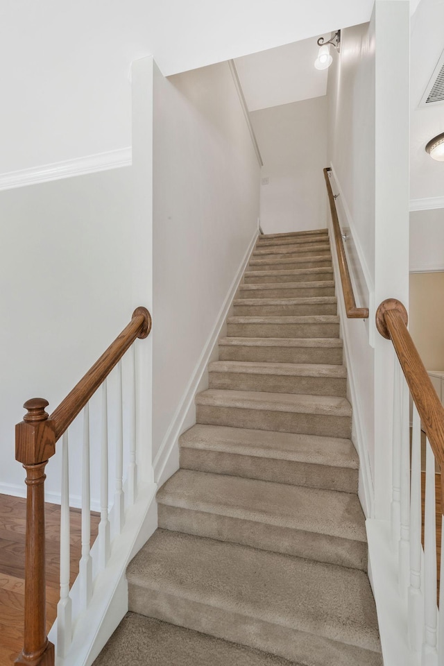 stairs featuring wood finished floors and visible vents