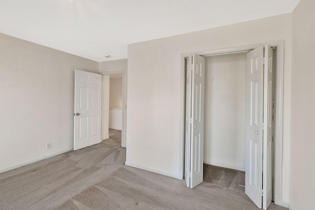 unfurnished bedroom with carpet floors, baseboards, and a closet