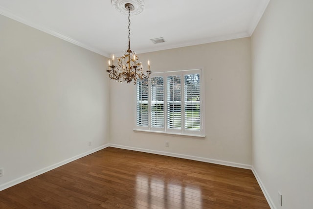 empty room with crown molding, a notable chandelier, visible vents, and hardwood / wood-style flooring