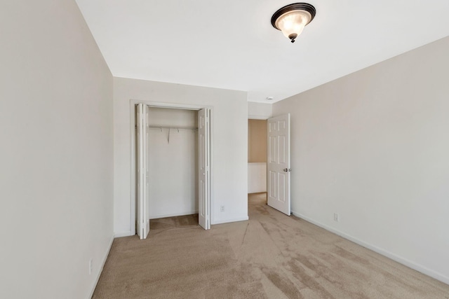 unfurnished bedroom with carpet flooring, baseboards, and a closet