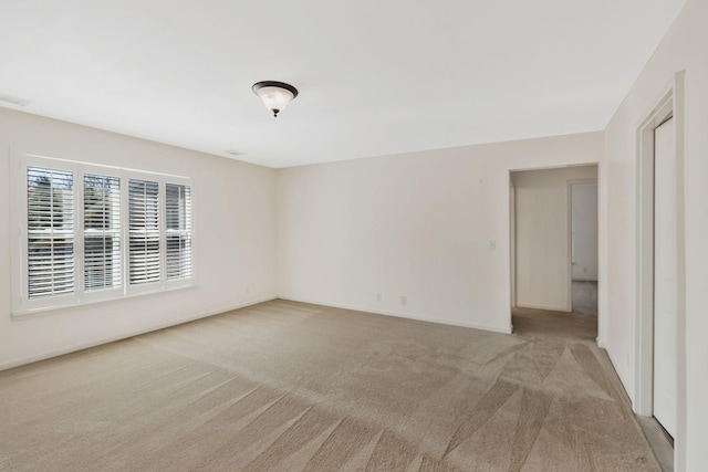 empty room with light carpet, baseboards, and visible vents