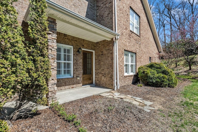 entrance to property with a patio and brick siding