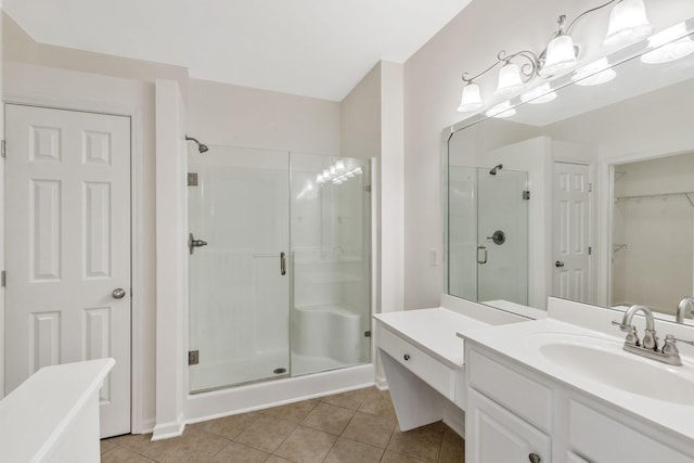 full bath with vanity, a spacious closet, tile patterned flooring, and a shower stall