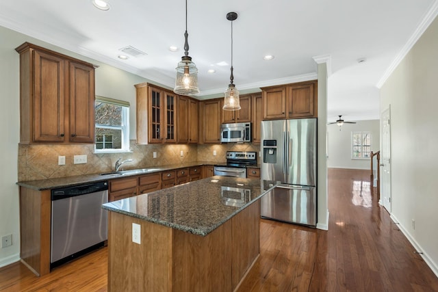 kitchen with visible vents, brown cabinets, stainless steel appliances, dark wood-type flooring, and a sink