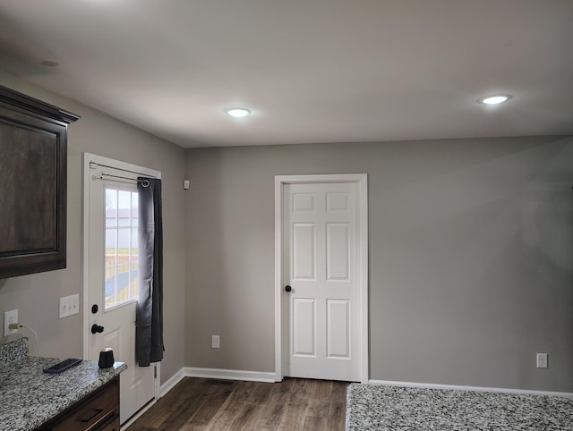 interior space featuring dark wood-type flooring, baseboards, and recessed lighting