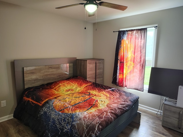 bedroom with baseboards, ceiling fan, and wood finished floors