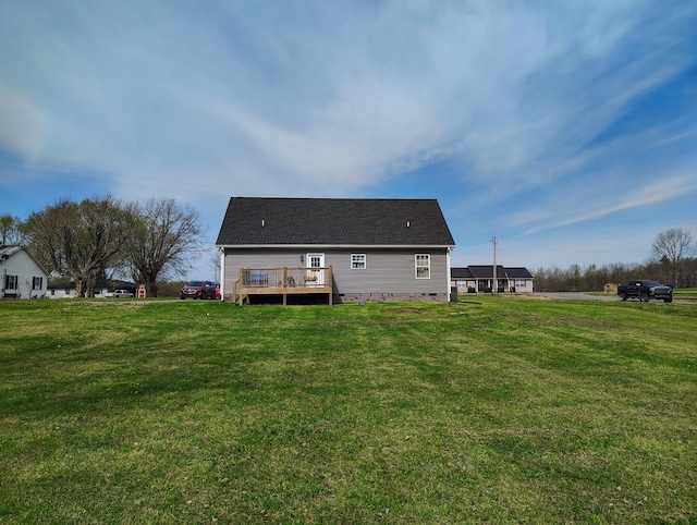 rear view of property featuring a lawn, crawl space, and a deck