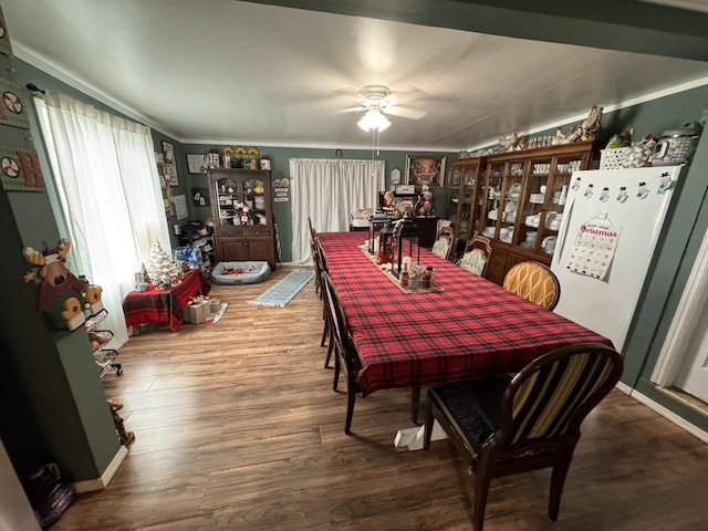 dining space featuring a ceiling fan, ornamental molding, and wood finished floors