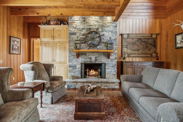 living room featuring a fireplace, wooden walls, wood ceiling, and beam ceiling