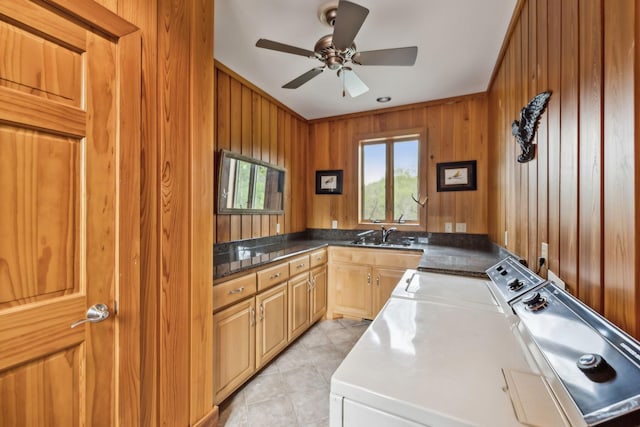 laundry room featuring ceiling fan, cabinet space, wood walls, washing machine and dryer, and light tile patterned flooring