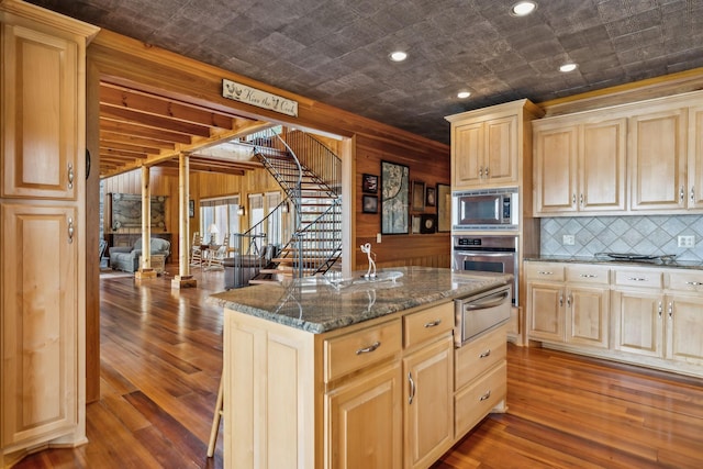 kitchen featuring dark wood-type flooring, a warming drawer, light brown cabinets, and stainless steel appliances