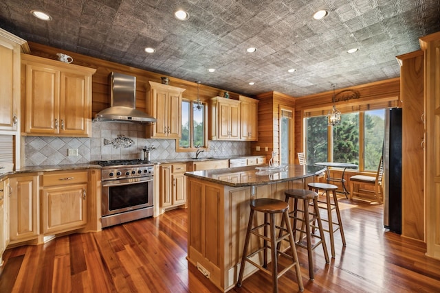 kitchen featuring an ornate ceiling, wall chimney range hood, appliances with stainless steel finishes, and dark wood finished floors
