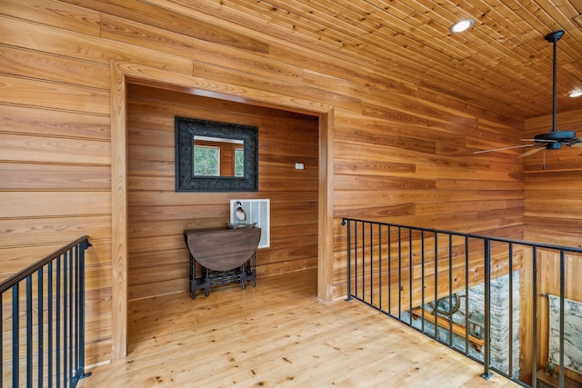 hall with wooden ceiling, wooden walls, and hardwood / wood-style flooring