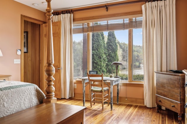 bedroom featuring light wood finished floors and baseboards