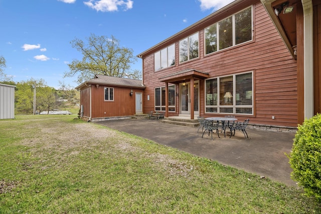 back of property with entry steps, a patio, and a yard