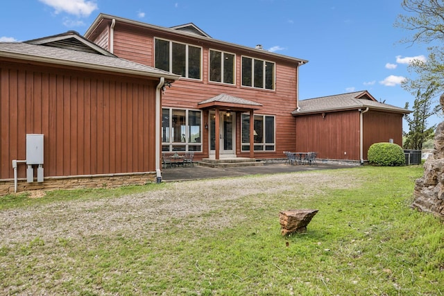 rear view of property with a patio and a yard
