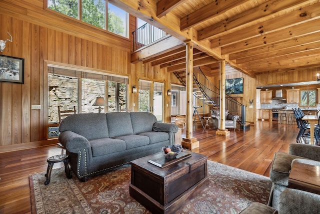 living area with wooden walls, plenty of natural light, and stairs