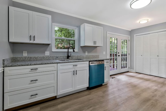 kitchen with white cabinets, ornamental molding, a sink, dishwasher, and light wood-style flooring