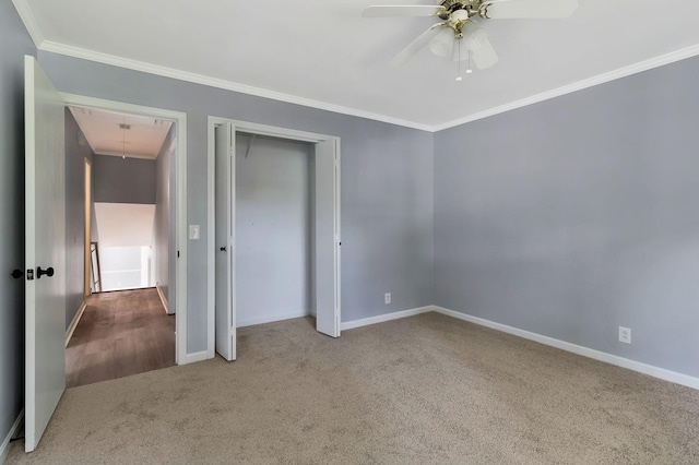 unfurnished bedroom featuring baseboards, ornamental molding, carpet, and attic access