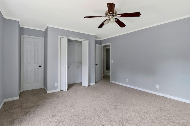 unfurnished bedroom featuring a closet, ornamental molding, carpet, and baseboards