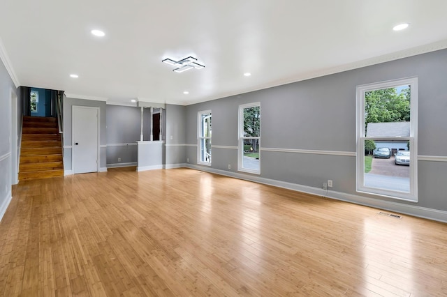 spare room with light wood-type flooring, a wealth of natural light, and visible vents