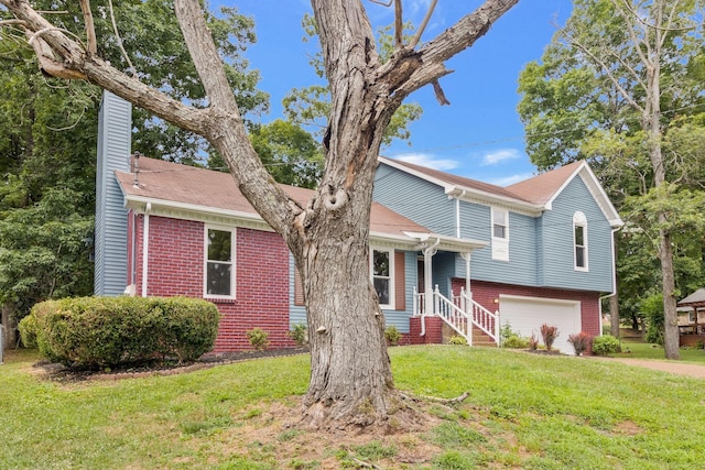tri-level home featuring an attached garage, a chimney, a front yard, brick siding, and driveway