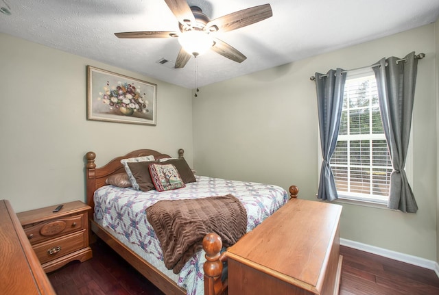 bedroom with visible vents, dark wood-type flooring, baseboards, and a textured ceiling
