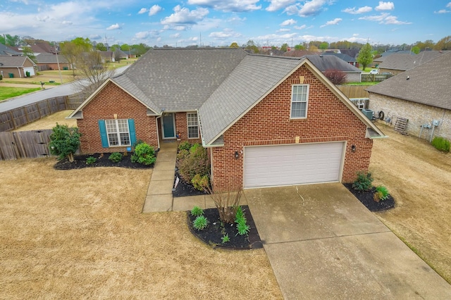 traditional-style house with fence, a garage, brick siding, roof with shingles, and driveway