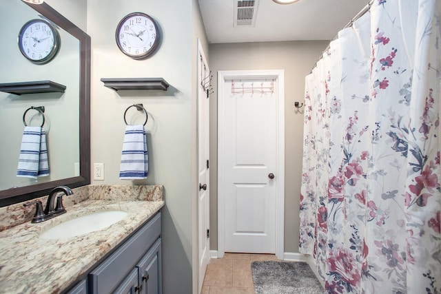 full bath featuring curtained shower, vanity, tile patterned flooring, baseboards, and visible vents