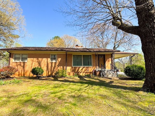 126 Zimmerman St, Hohenwald, TN 38462 - view of front of house featuring a chimney, brick siding, and a front lawn
