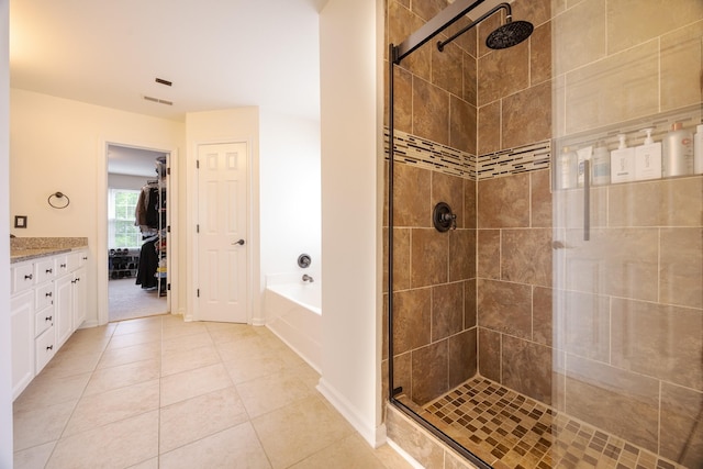 full bath featuring tile patterned flooring, vanity, a shower stall, visible vents, and a garden tub