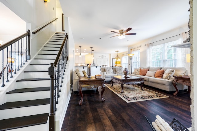 living area featuring a ceiling fan, wood finished floors, and stairway
