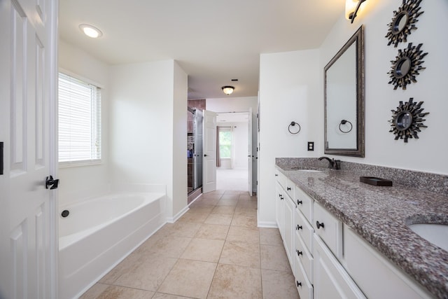 bathroom with a sink, tile patterned flooring, double vanity, a shower stall, and a garden tub