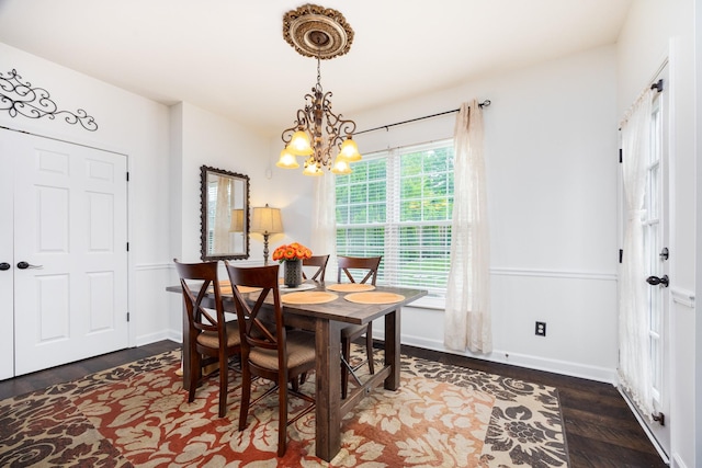 dining area featuring baseboards, a notable chandelier, and wood finished floors