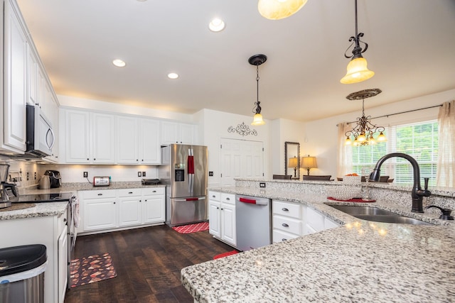 kitchen with dark wood-style flooring, a sink, white cabinets, a notable chandelier, and stainless steel appliances