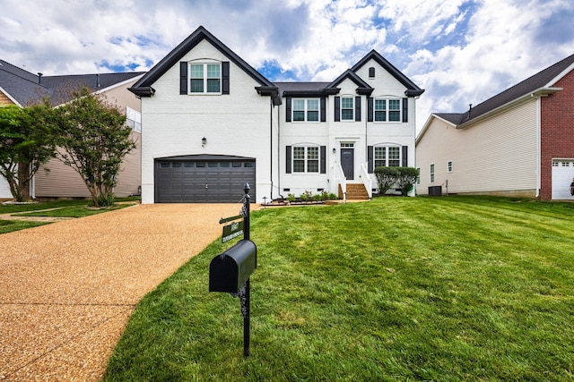traditional-style house with an attached garage, a front lawn, brick siding, crawl space, and driveway