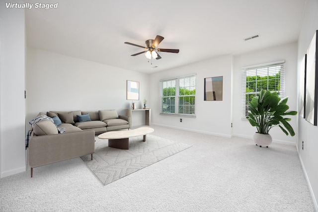 living area with a healthy amount of sunlight, a ceiling fan, carpet flooring, and visible vents