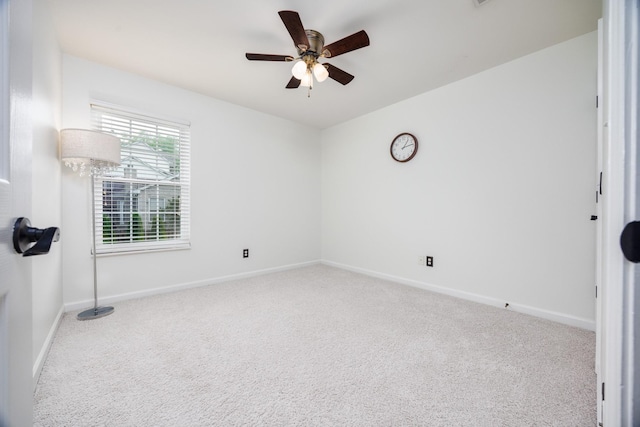 carpeted spare room featuring baseboards and ceiling fan