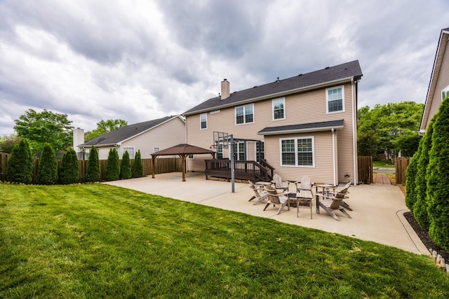 back of property featuring a chimney, a gazebo, fence, a yard, and a patio