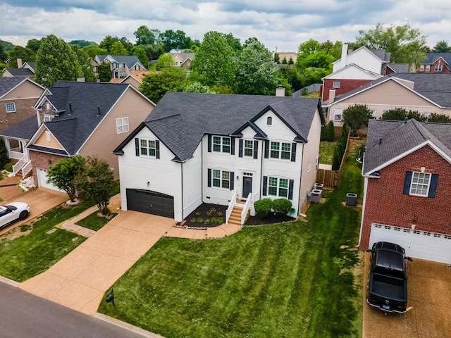 view of front of property featuring a garage, driveway, roof with shingles, and a residential view