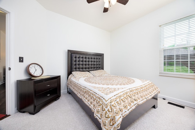 bedroom featuring baseboards, light colored carpet, ceiling fan, and visible vents