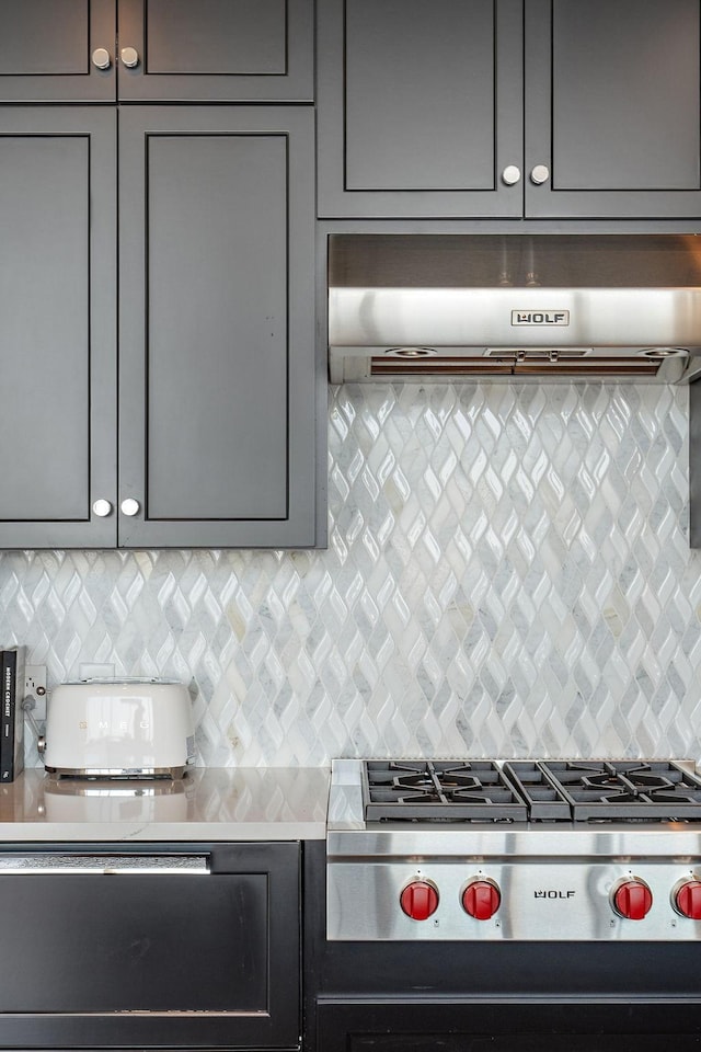515 Church St Unit 3908, Nashville, TN 37219 - kitchen featuring range hood, stovetop, gray cabinets, light countertops, and decorative backsplash