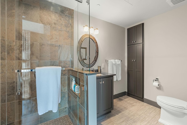515 Church St Unit 3908, Nashville, TN 37219 - bathroom featuring tiled shower, toilet, vanity, and wood finished floors