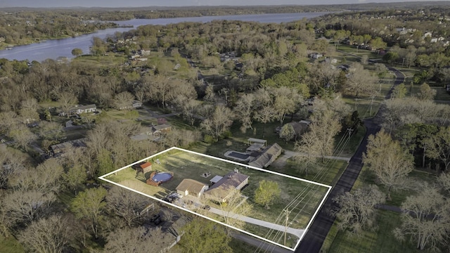 drone / aerial view with a water view and a forest view
