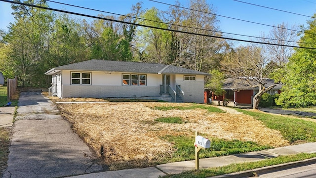 ranch-style house with brick siding, aphalt driveway, and stucco siding