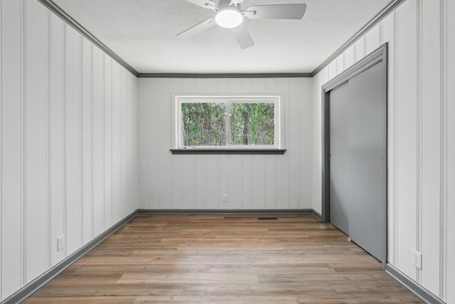 unfurnished bedroom featuring visible vents, ornamental molding, light wood finished floors, and a closet